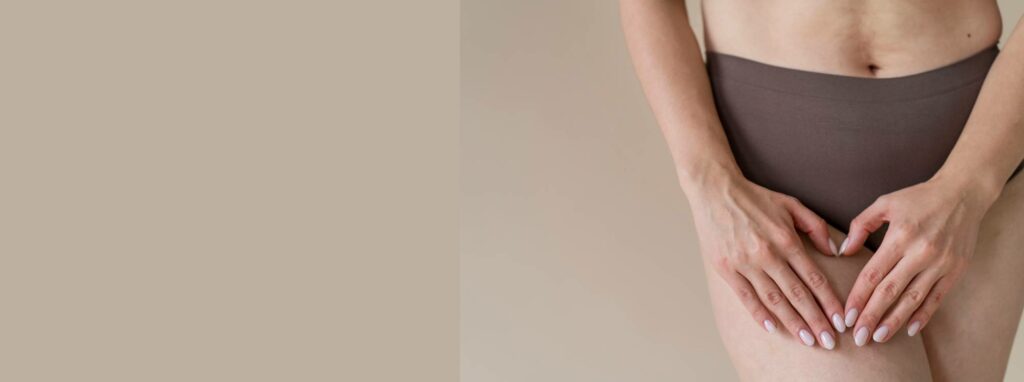 A woman in brown underwear forming a heart shape with her hands over her lower abdomen