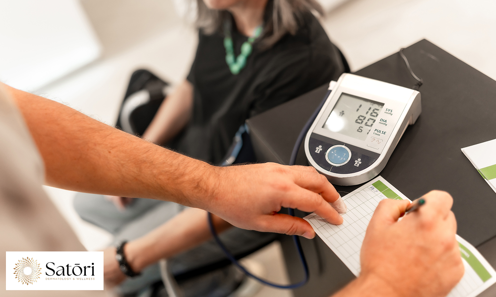 Doctor writing the measures of female blood pressure