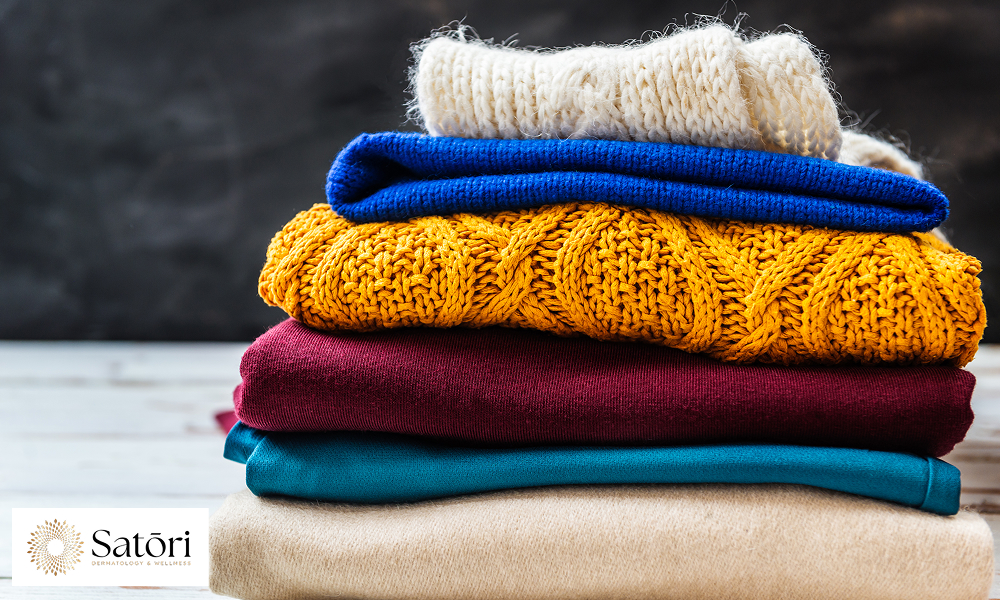 Stack of sweaters showing clothing choices that can increase sweating.